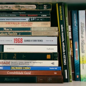 A neatly arranged bookshelf featuring books on economics, politics, and literature in Portuguese.