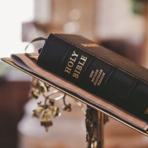 Holy Bible open on a stand inside a church, symbolizing faith and spirituality.